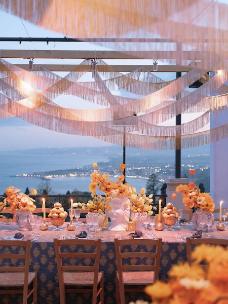 In questa foto una tavola allestita in stile siciliano, con teste di moro al centro e fiori gialli, in occasione della prima serata di Engage 2023 a Taormina