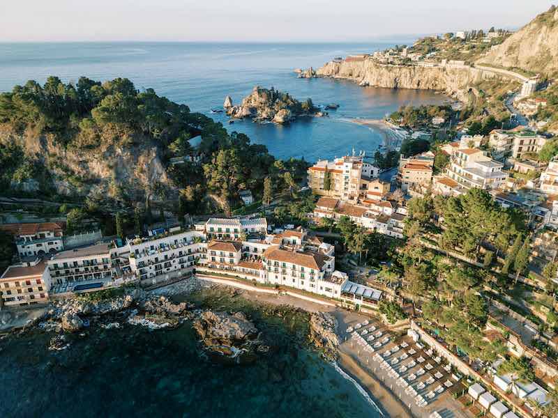 In questa foto una veduta aerea di Villa Sant’Andrea, hotel del gruppo Belmond, a Taormina Mare, che ha ospitato la quarantesima edizione di Engage Summit