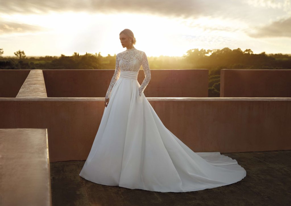 In questa immagine un abito con corpetto in pizzo e gonna fluida della nuova collezione sposa del brand spagnolo.