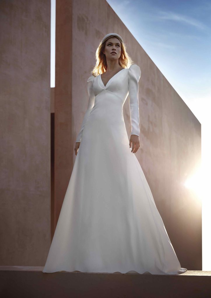 In questa immagine un abito con minimal con maniche lunghe della nuova collezione sposa del brand spagnolo.