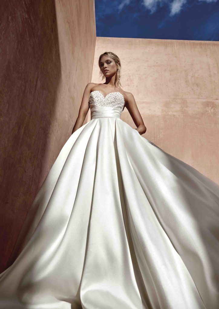 In questa immagine un abito della collezione The Journey di Pronovias con corpetto prezioso ed ampia gonna.