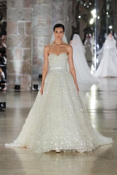 In questa foto una modella sfila durante la Barcelona Bridal Night, mentre indossa un abito da sposa Elie Saab 2024