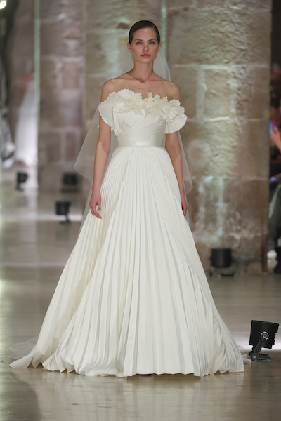 In questa foto una modella indossa un vestito da sposa plissettato di Elie Saab 2024, grandissimo protagonista della Barcelona Bridal Fashion Week