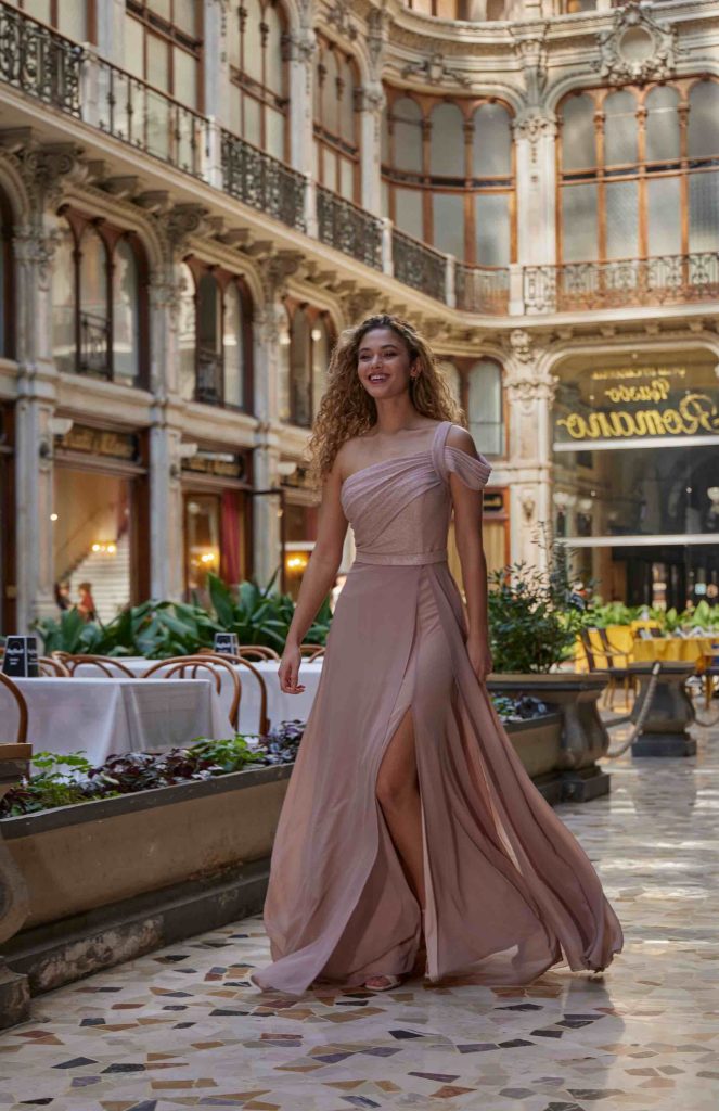 In questa immagine un abito con spacco rosa della maison italiana