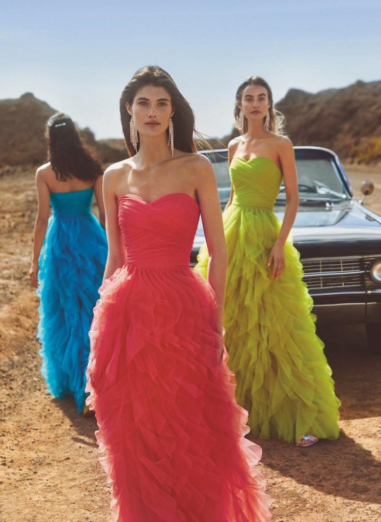 In questa foto tre modelle indossano tre vestiti da damigelle 2023 Atelier Emé lunghi in tulle  di colore rosso, verde lime e turchese