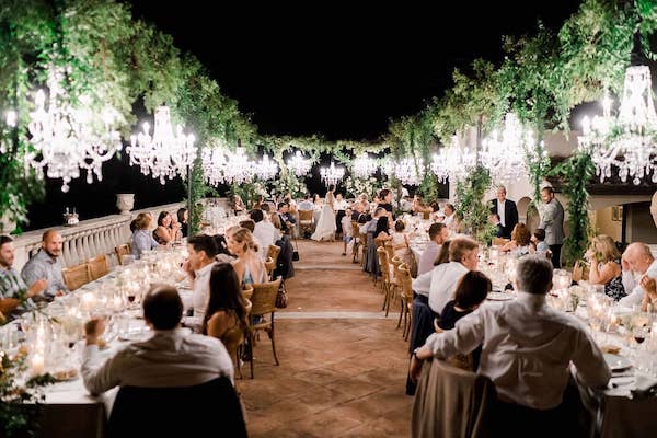 In questa immagine un allestimento da sogno con chandelier che sovrastano i tavoli imperiali. 