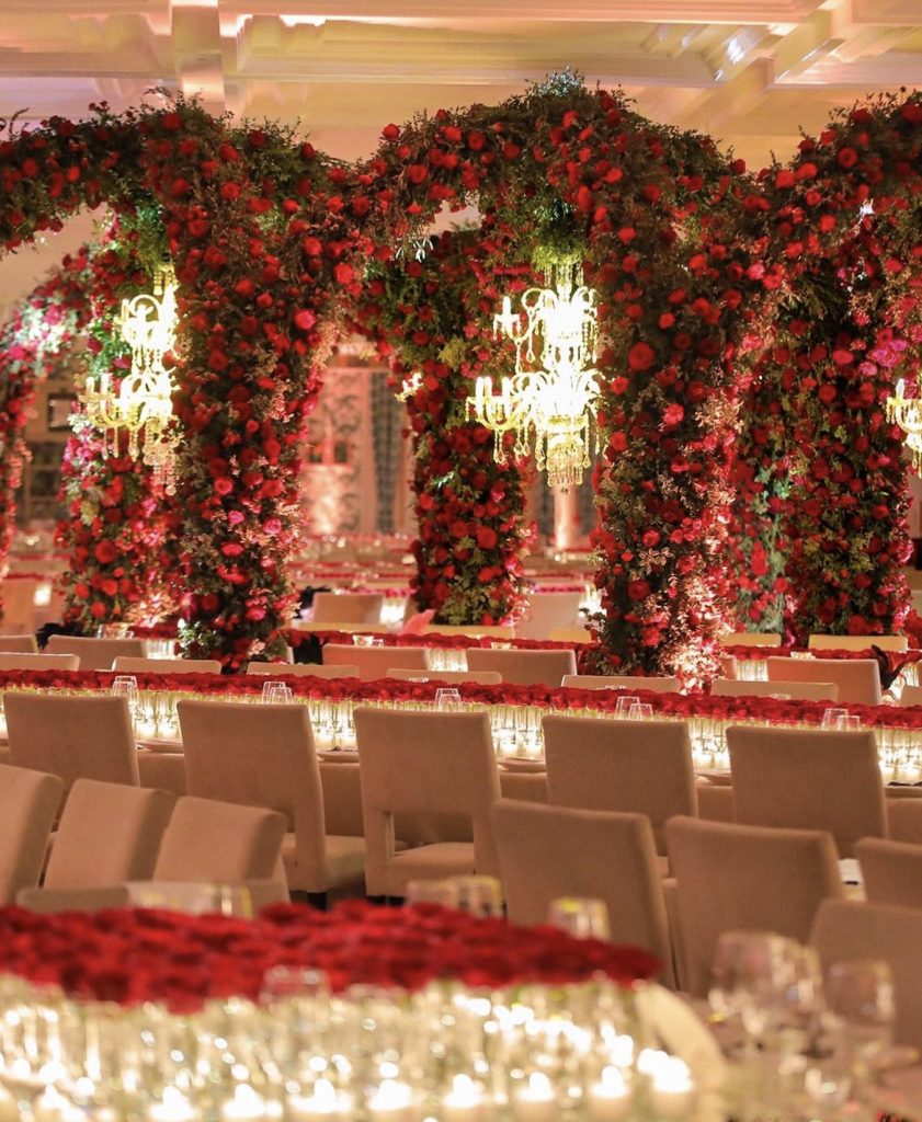 In questa immagine un allestimento opulento con maxi archi di rose rosse di Cira Lombardo