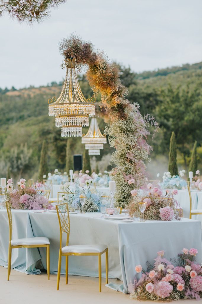 In questa immagine un allestimento da sogno con chandelier imponenti e tonalità pastello.