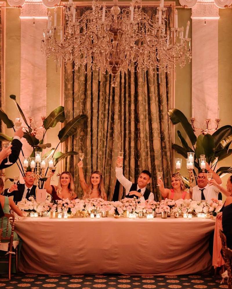 In questa foto Lautaro Martinez e Agustina Gandolfo seduti al tavolo imperiale mentre brindano con la famiglia durante il ricevimento del matrimonio