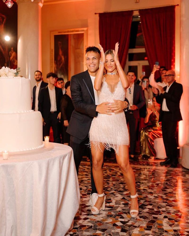 In questa foto Lautaro Martinez e Agustina Gandolfo ballano dietro alla torta nuziale. Lei indossa un mini dress di Atelier Emé con frange scintillanti