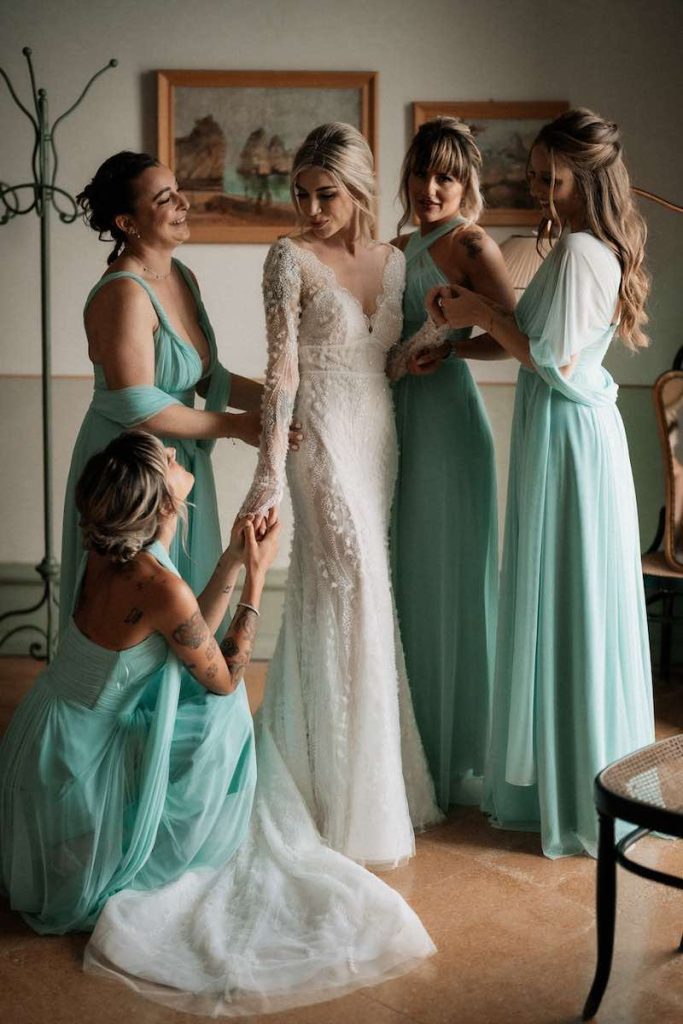 In questa foto Nina Rima indossa il suo abito da sposa a sirena in tulle con ricami 3D con le sue quattro damigelle che indossano il modello da cerimonia Venezia nel colore turchese
