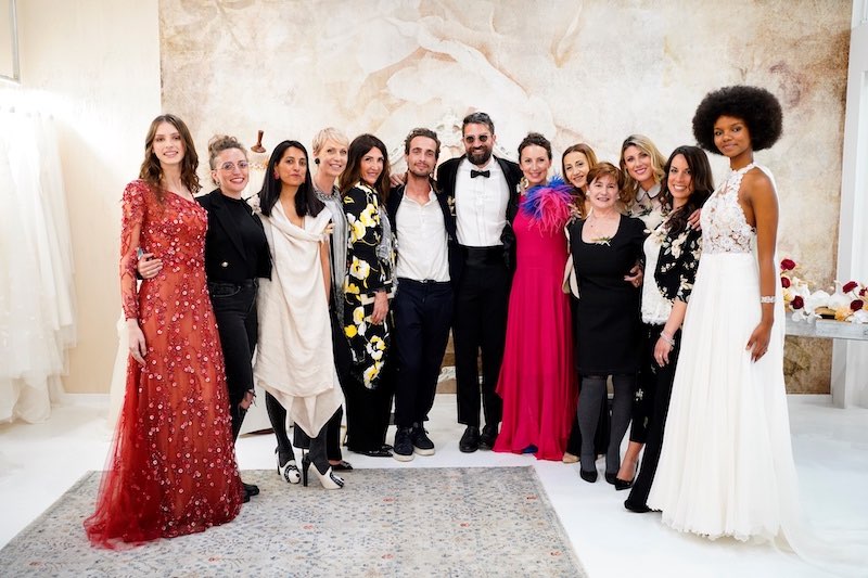 In questa foto le stiliste Sarah e Corinna insieme al loro staff al termine del loro fashion show in atelier alla Milano Bridal Week 2023