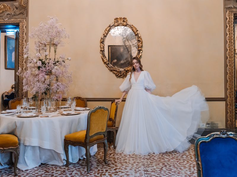 In questa foto una modella indossa un abito da sposa in un salone nobiliare di Milano allestito per un matrimonio con gypsophila di colore rosa