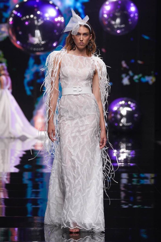 In questa foto una modella sfila con un abito da sposa a sirena di Elisabetta Polignano ricamato con cinturone e spalline in rafia 