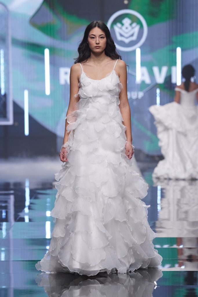 In questa foto una modella sfila indossando un abito da sposa scivolato con scollo quadrata e balze all over di organza di Rara Avis