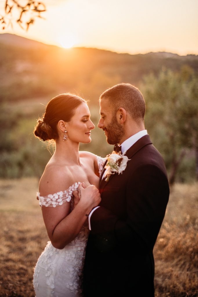 In questa foto realizzata dallo Studio Argentieri gli sposi Jessica e John si stringono in un abbraccio al tramonto 