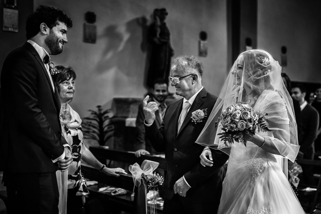 In questa foto Myriam e Francesco si incontrano all'altare, mentre il papà di lei raccomanda lo sposo prima del Sì: lo scatto di Gianfranco Bernardo, tra i fotografi di matrimonio a Firenze iscritti ad ANFM