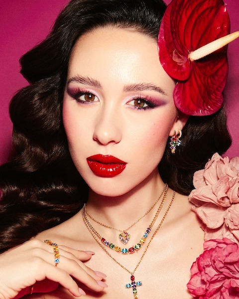 In questa foto Aurora Ramazzotti, protagonista della campagna pubblicitaria Morellato, mostra una serie di collane con ciondoli coloratissimi inseriti nella collezione di gioielli donna 2023 del brand
