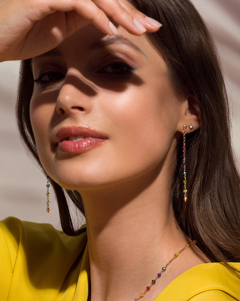 In questa foto una modella con indosso un paio di orecchini lunghi, sottili e colorati di Stroili