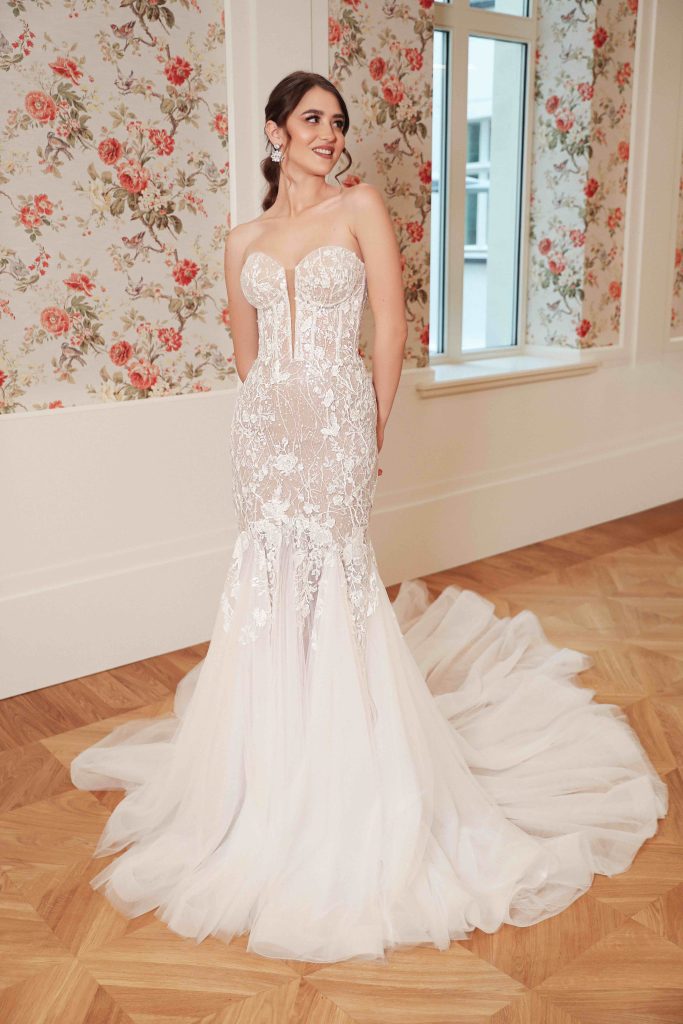 In questa immagine un abito da sposa Annais Bridal 2024 a sirena in pizzo con la gonna in tulle che si apre. 