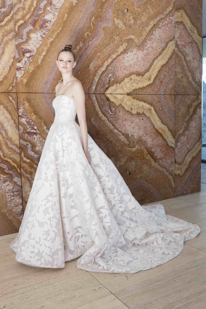 In questa immagine un abito da sposa ampio con decorazioni in pizzo. 