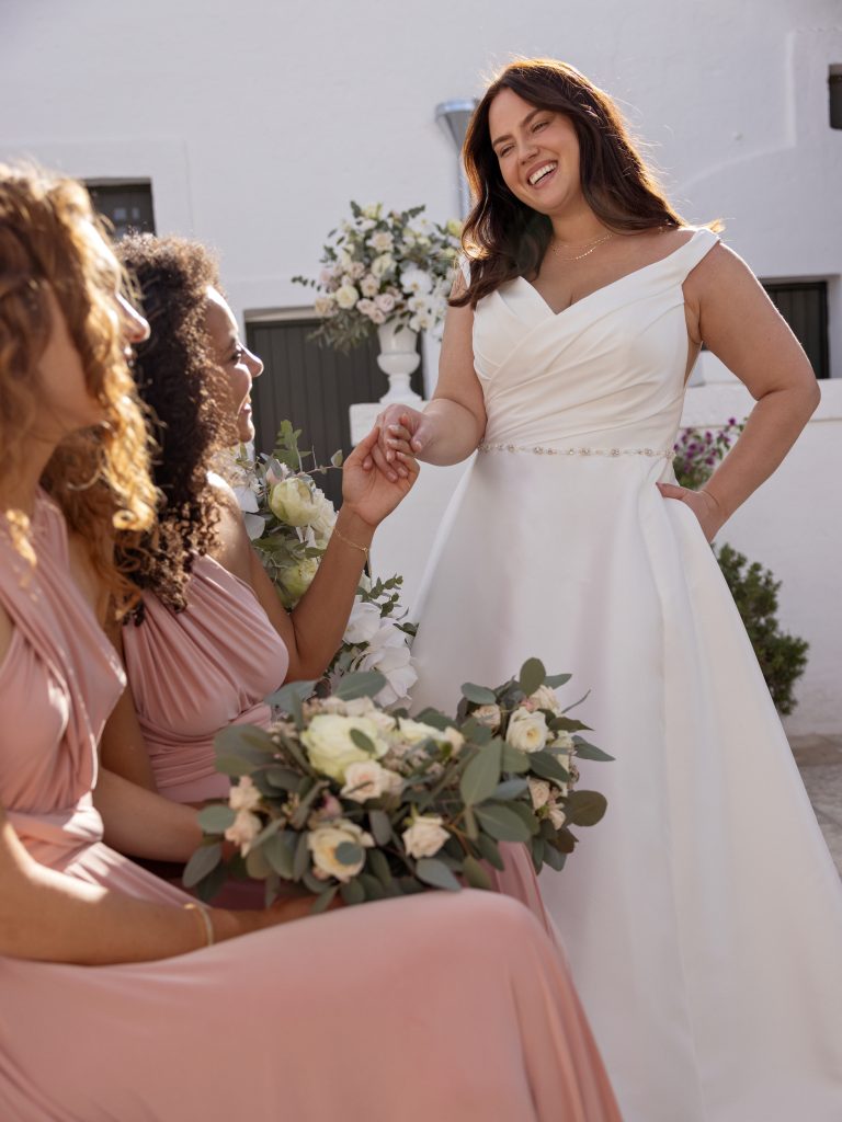 In questa immagine un abito da sposa di Victoria Collection by Curves, con spacco e ricami floreali. 