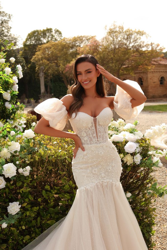 In questa immagine un abito da sposa a sirena con maniche staccabile e decorazioni floreali in 3D.