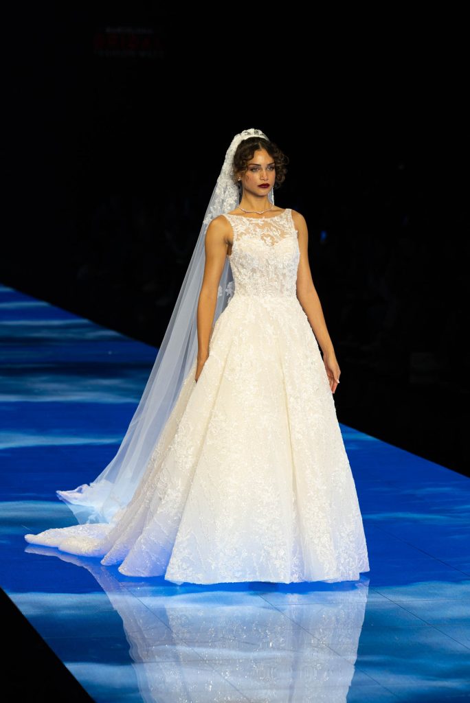 In questa immagine una modella indossa un vestito ampio in pizzo, da principessa.
