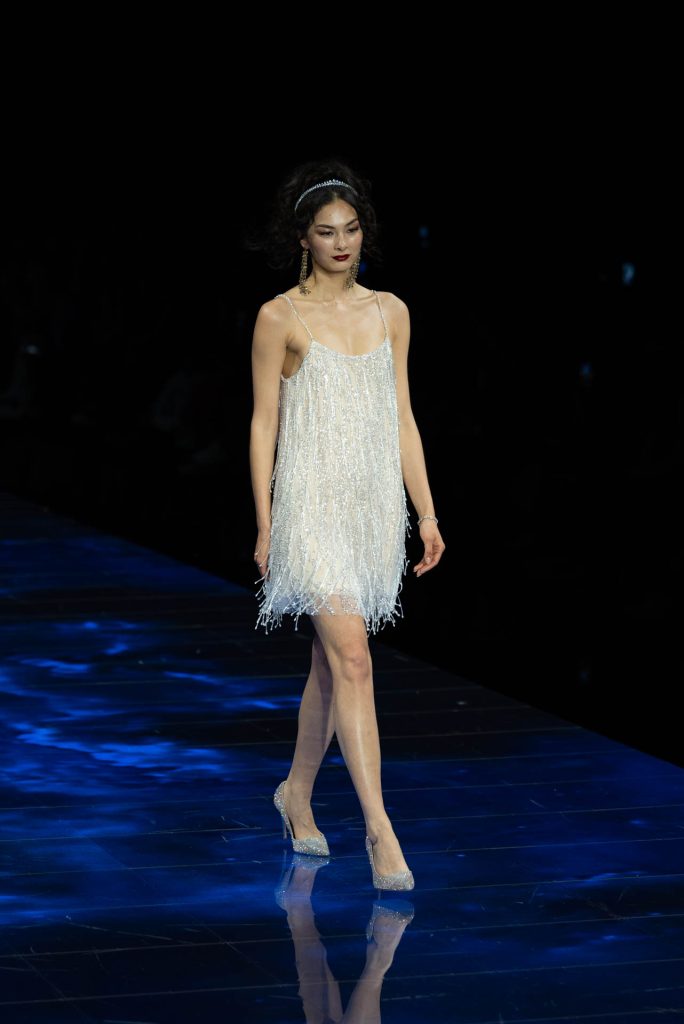 In questa immagine una modella indossa un vestito corto con frange.