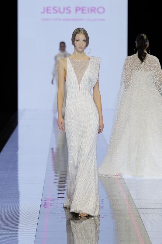 In questa immagine un abito da sposa Jesus Peiro 2024 dal tessuto brillante.
