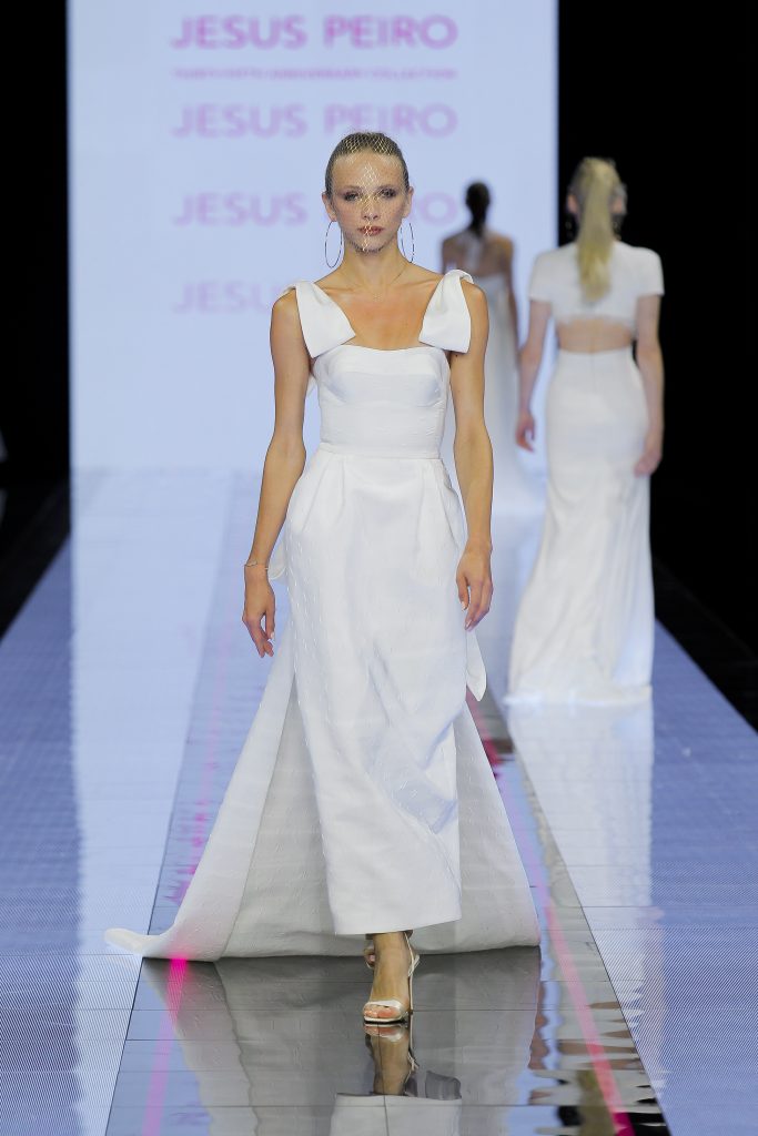 In questa immagine un abito da sposa Jesus Peiro 2024 con romantici fiocchi sulle spalle.