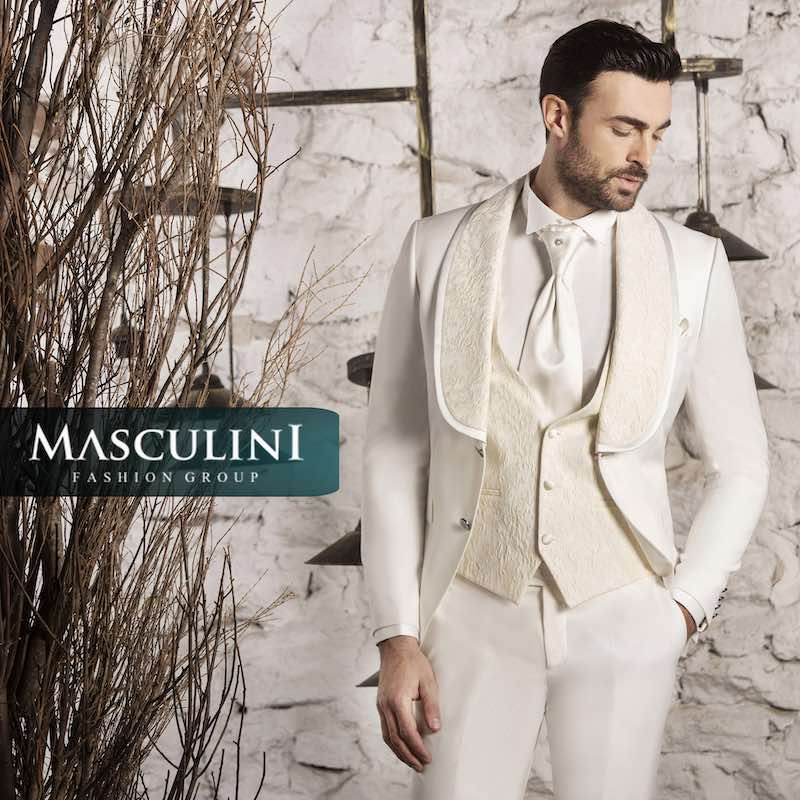 In questa foto un modello indossa un abito da sposo bianco con revers sciallati e gilet a due bottoni