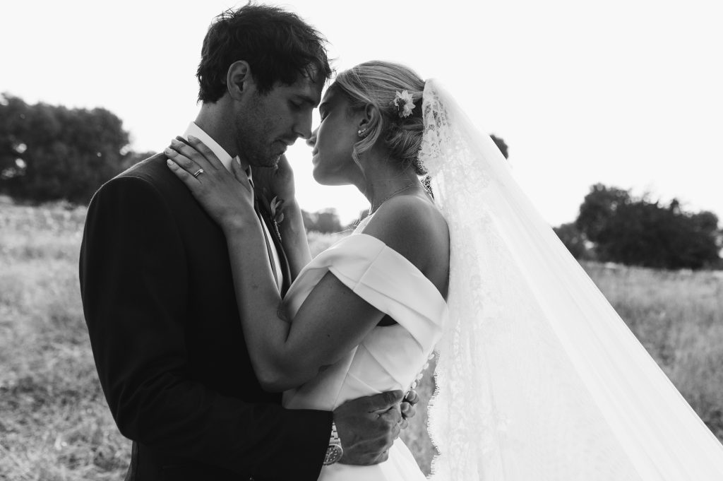 In questa foto in bianco e nero gli sposi Martina e Federico si baciano in campagna: lo scatto è realizzato da Vanessa Serra, tra i fotografi di matrimonio a Bari iscritti ad ANFM