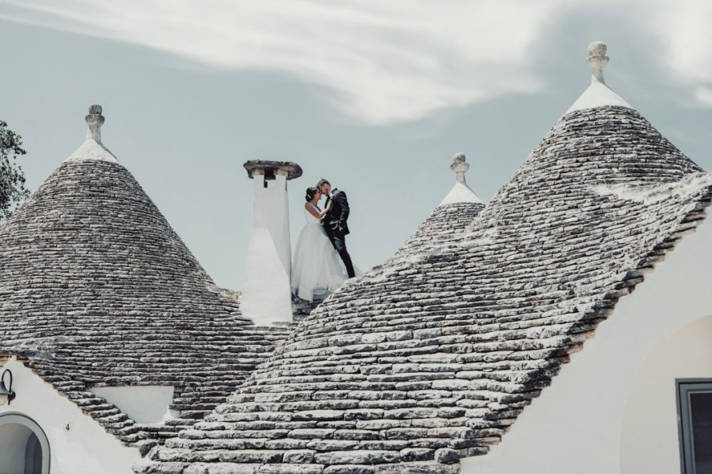 In questa foto gli sposi Monica e Alessando tra i trulli di Alberobello: lo scatto è realizzato da Giancarlo Pappone, tra i migliori fotografi di matrimonio a Bari