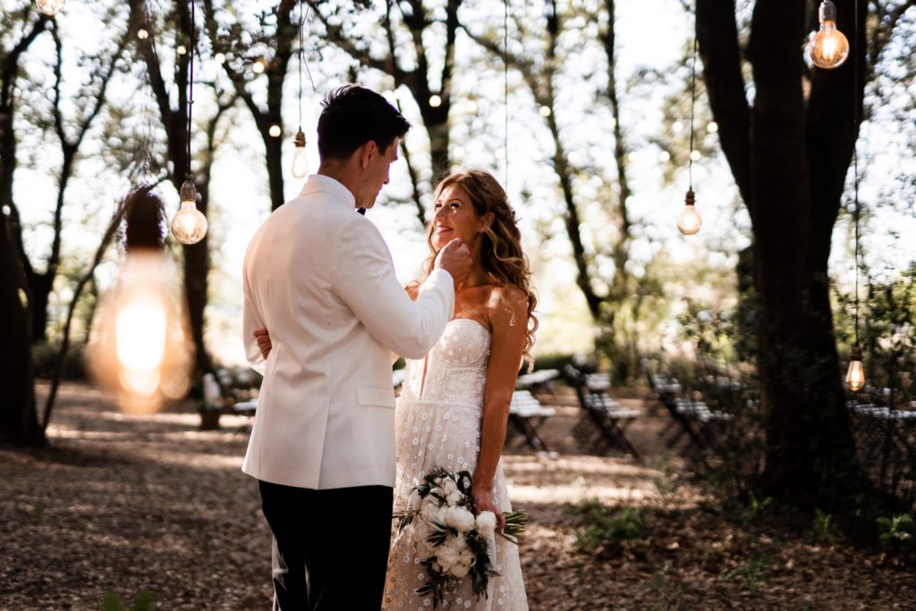 In questa foto il Destination Wedding di Stephanie e Scott realizzato da Lorena Caramia, tra i fotografi di matrimonio dello Studio Morlotti a Bari: i due sposi si accarezzano in un bosco illuminato da lampadine