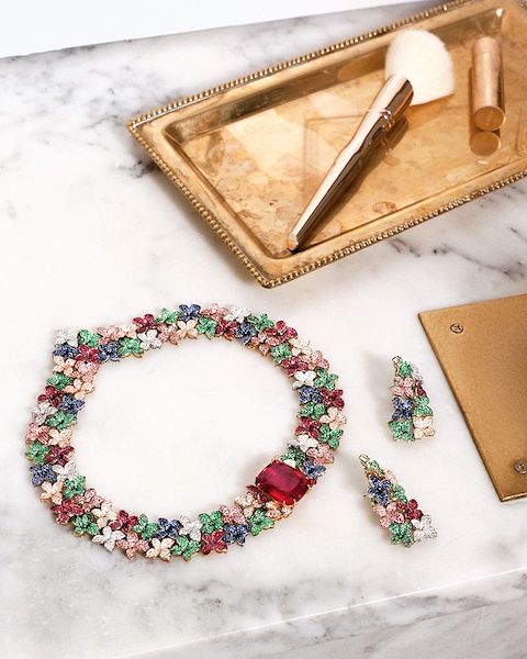 In questa foto un collier multicolor, che rimanda al mondo floreale, con grande pietra magenta al centro, della collezione di gioielli per la donna 2023 di Pasquale Bruni. Sono abbinanti anche gli orecchini