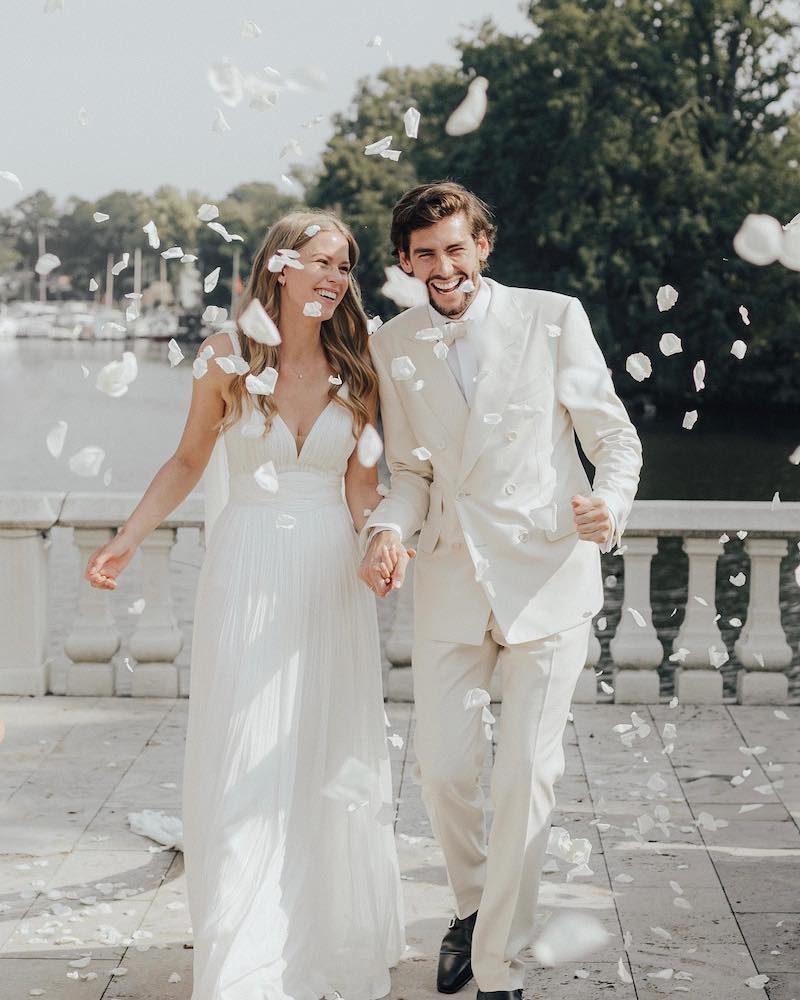 In questa foto un momento del matrimonio di Alvaro Soler con Melanie Kroll mentre corrono felici e sorridenti tra petali bianchi