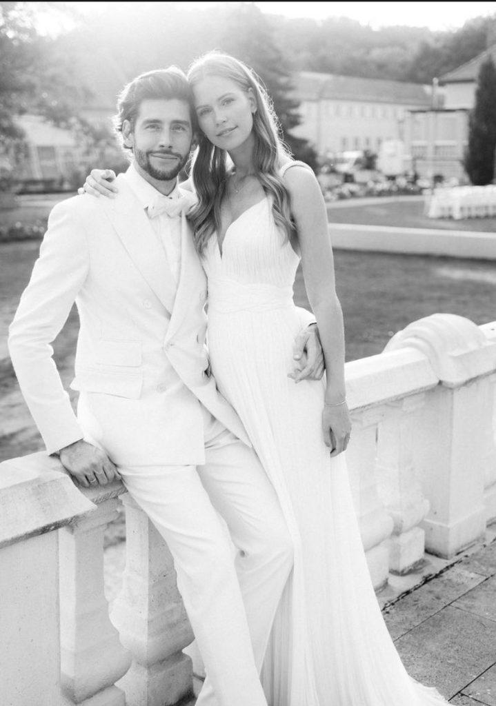 In questa foto in bianco e nero Melanie Kroll e Alvaro Soler posano seduti sulla balaustra della location del matrimonio