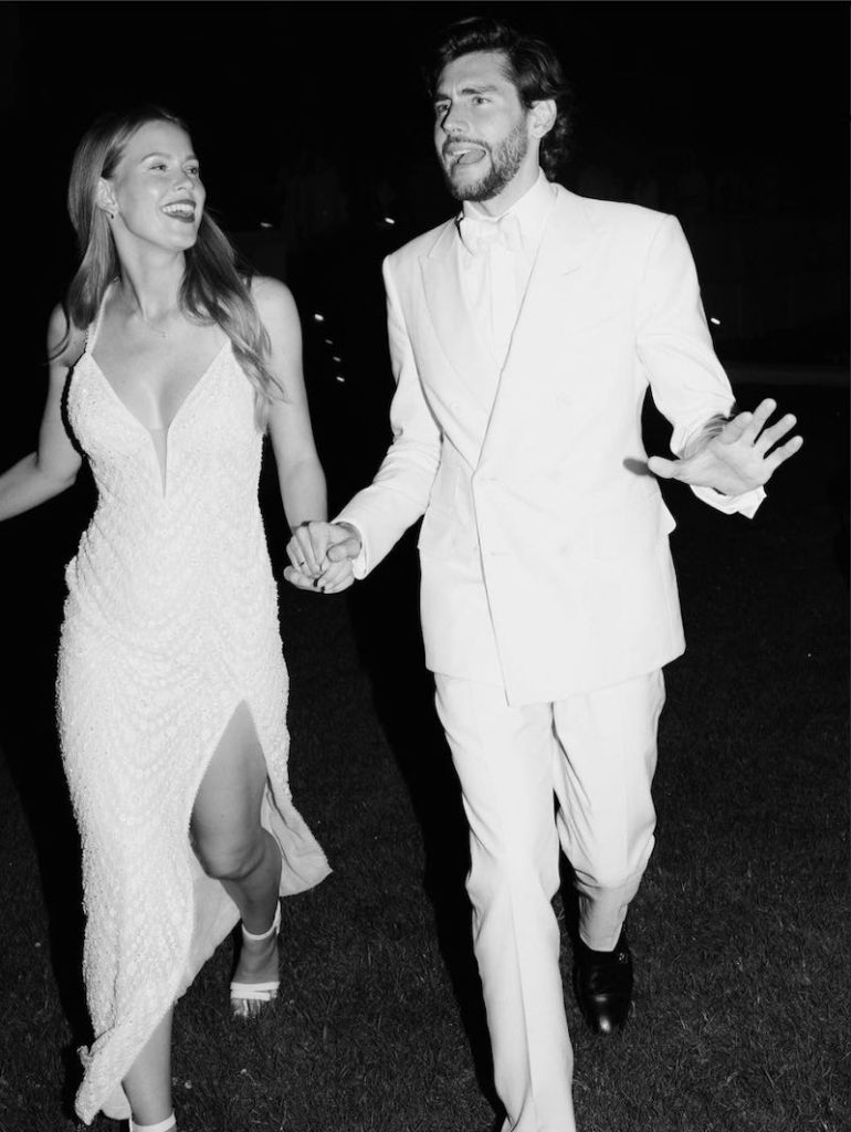 In questa foto in bianco e nero Melanie Kroll e Alvaro Soler corrono felici tenendosi per mano