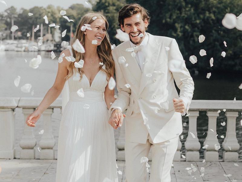 In questa foto il matrimonio di Alvaro Soler e Melanie Kroll: i due corrono felici e sorridenti circondati da petali bianchi