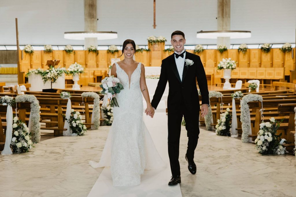 In questa immagine Giulio Maggiore e Laura Mencarelli escono mano nella mano dalla chiesa.