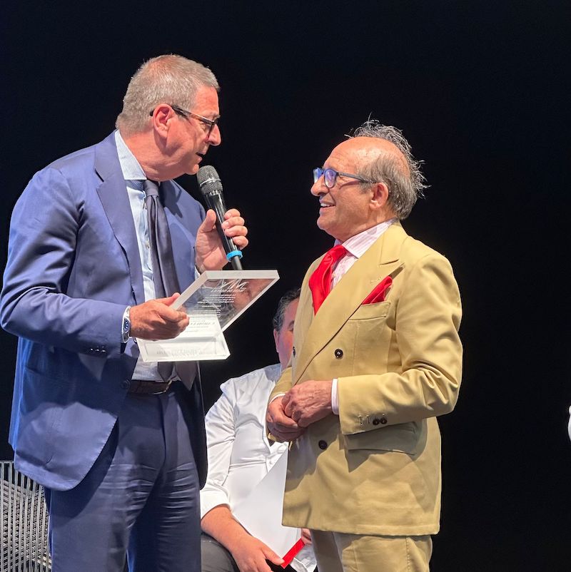 In questa foto Carmelo Crimi riceve il premio alla carriera sul palco del Pitti Uomo