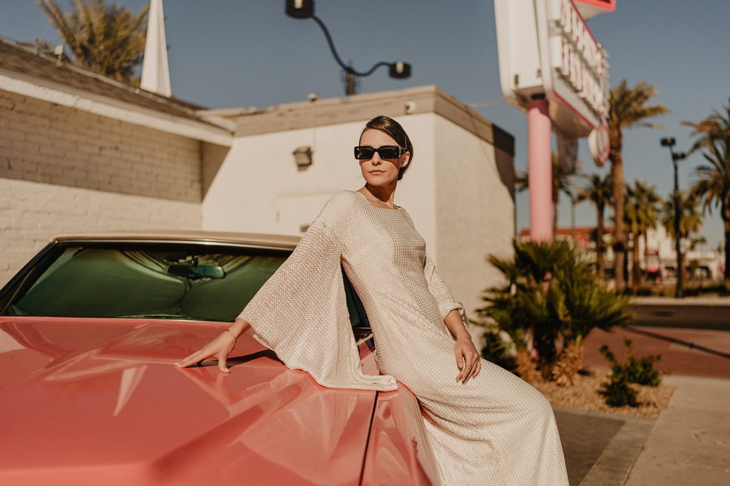 In questa immagine una sposa a bordo di una Cadillac rosa vintage