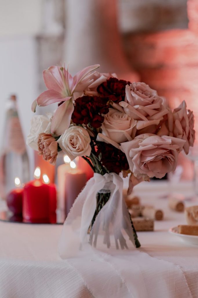 In questa foto un centrotavola  realizzato con un bouquet di fiori da OttoQuattro Eventi d Michele Squeri nei toni del rosa e del rosso