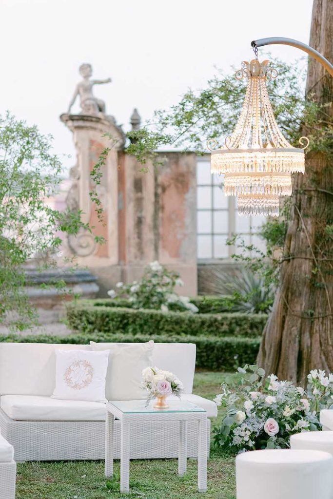 In questa foto il dettaglio dell'allestimento di un matrimonio su un prato realizzato da Giovanna Damonte nei colori del rosa, del bianco e del verde salvia con lampadari con cristalli 