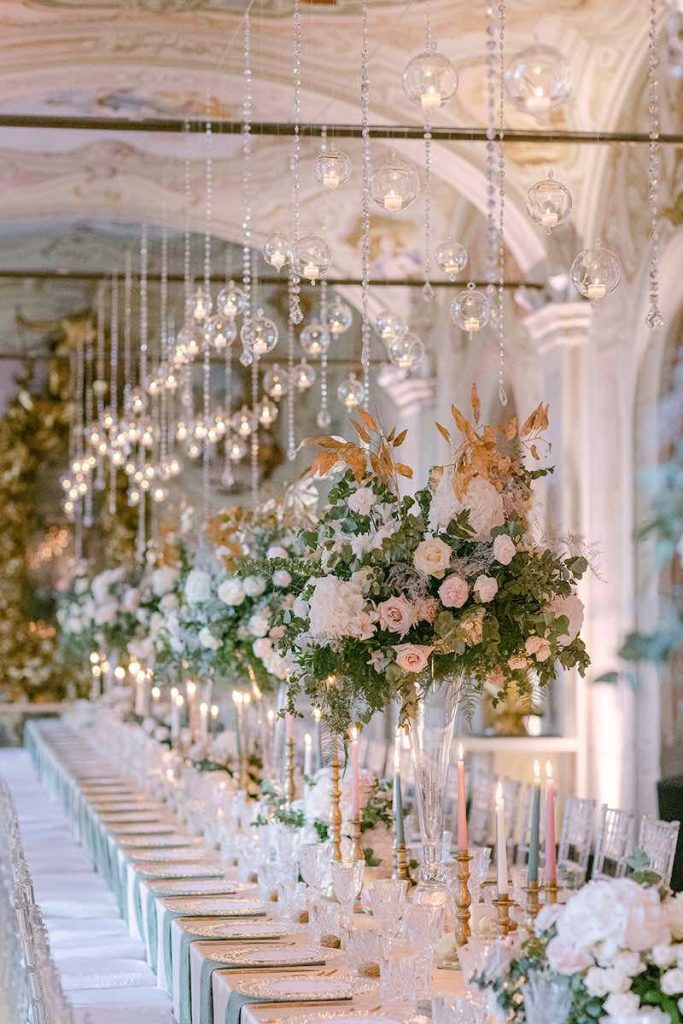 In questa foto un tavolo imperiale per matrimonio allestito da Giovanna Damonte con tovagliato, alzate di fiori e candele nei colori del rosa, del bianco e del verde salvia