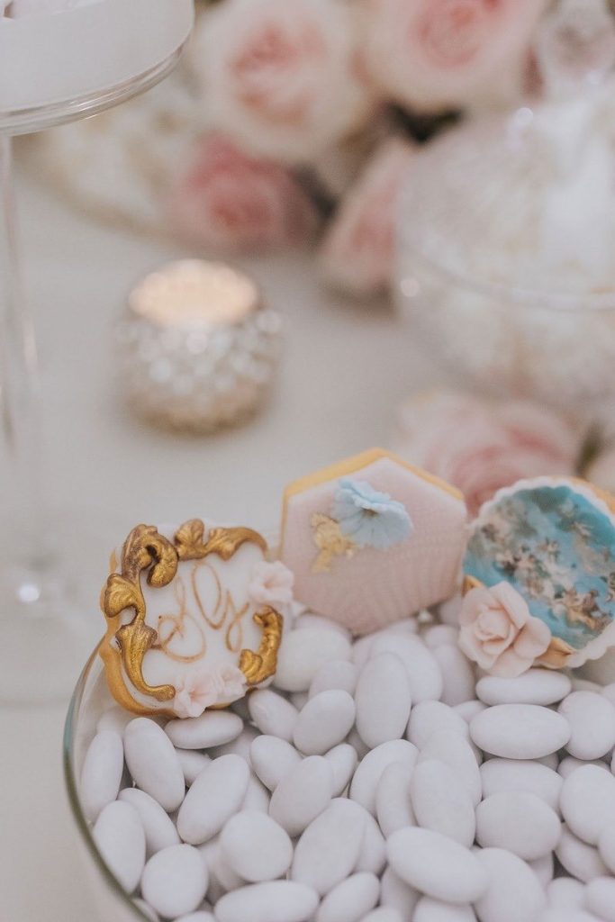 In questa foto il dettaglio dell'allestimento di un matrimonio nei toni del bianco e del rosa cipria realizzato da Giovanna Damonte con confetti e biscottini personalizzati