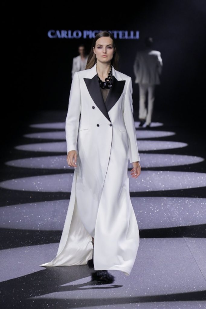 In questa foto una modella sfila indossando un cappotto da sposa doppiopetto di Carlo Pignatelli con revers a lancia di colore nero