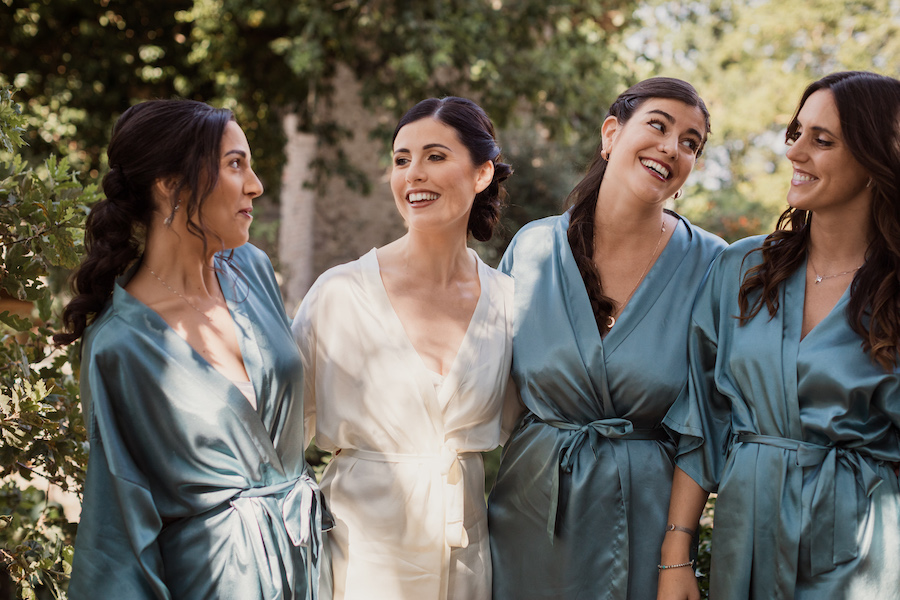 In questa foto una sposa con le sue damigelle, mentre attendono di prepararsi per il matrimonio. 