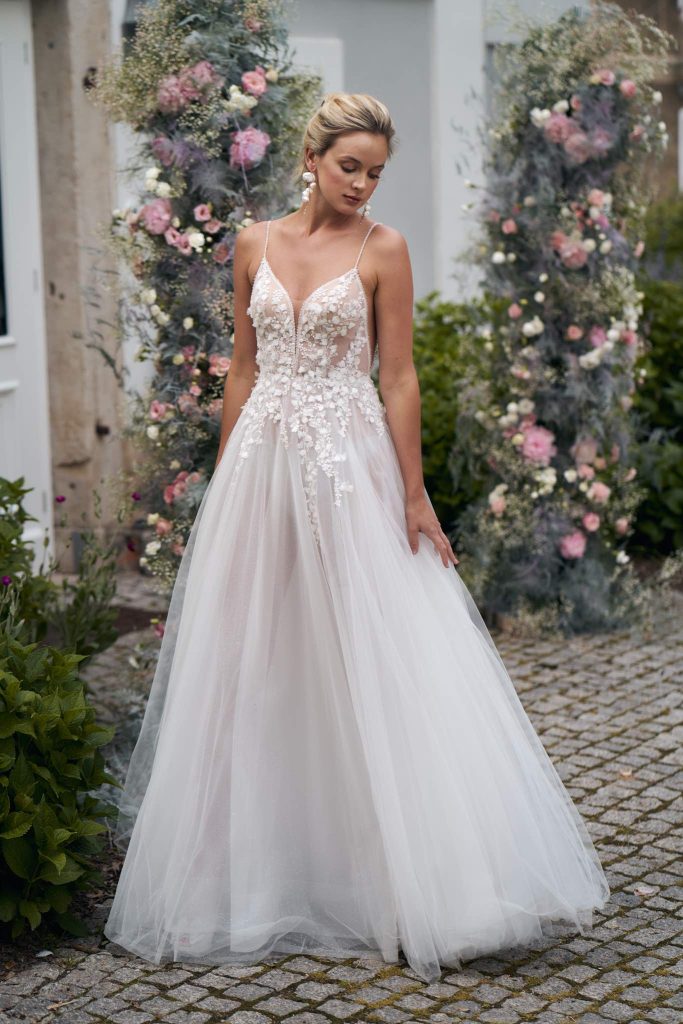 In questa immagine un abito da sposa con corpetto in pizzo, arricchito da fiori 3D, e la gonna in tulle. 